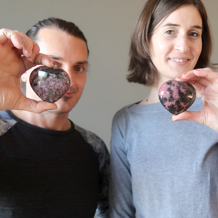 couple holding rhodonite hearts