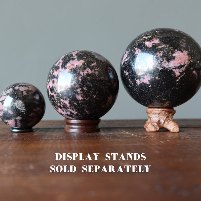 pink and black rhodonite spheres on stands