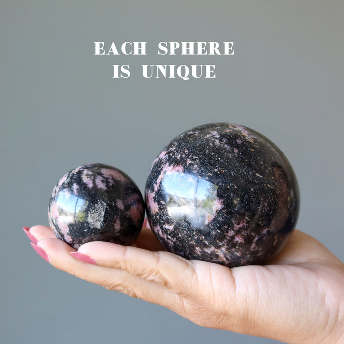 two pink and black rhodonite spheres