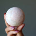 pink rhodonite sphere in hand
