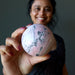 woman holding peruvian rhodonite sphere