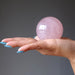 palm of hand holding a rose quartz sphere