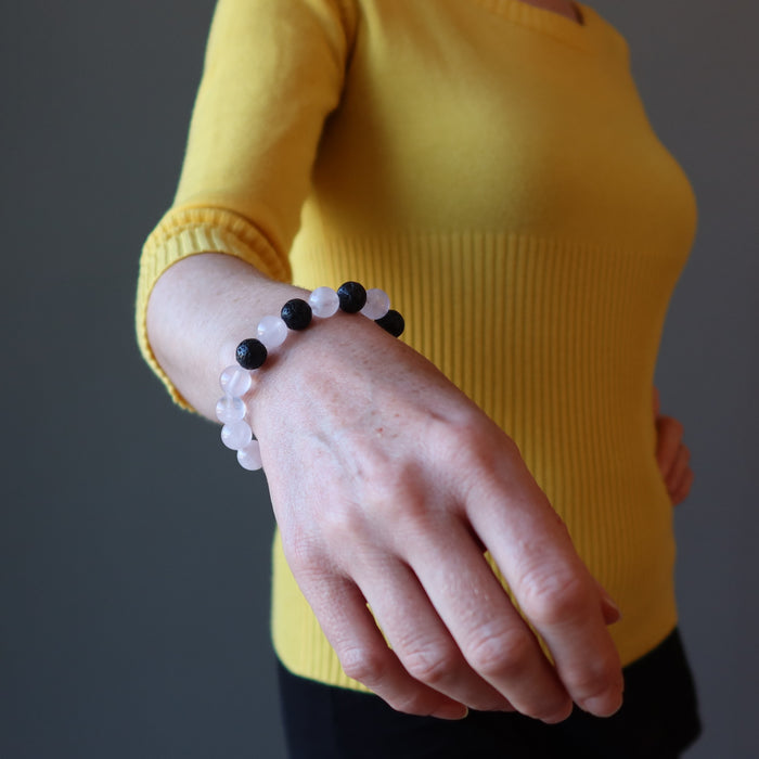 pink rose quartz and black lava stretch bracelet on the wrist of a woman 