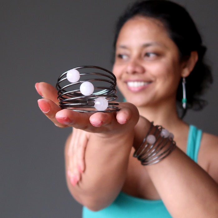Sheila of Satin Crystals holds one Rose Quartz memory bracelet in hand and wears another on her wrist