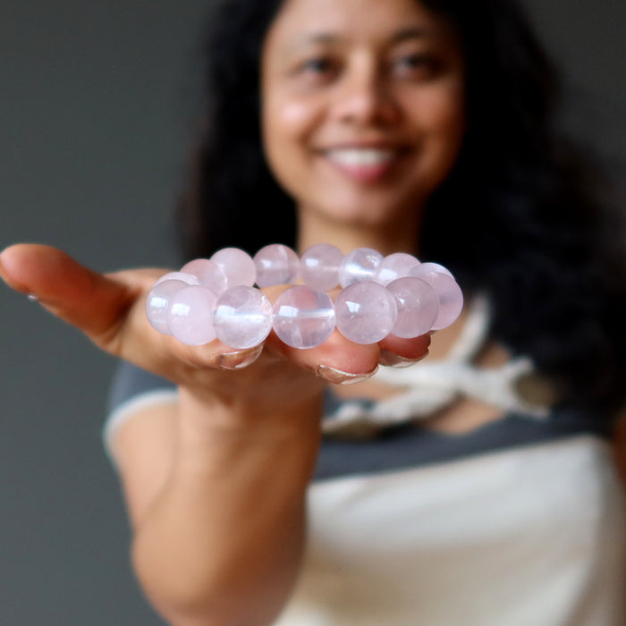 sheila of satin crystals holding a clear pink rose quartz round beaded stretch bracelet