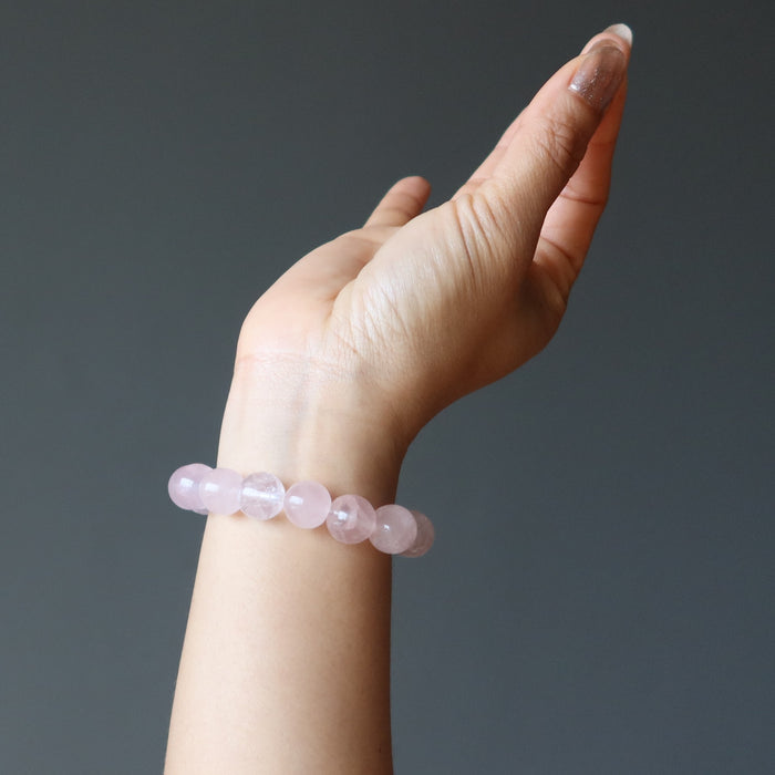hand wearing clear pink rose quartz round beaded stretch bracelet