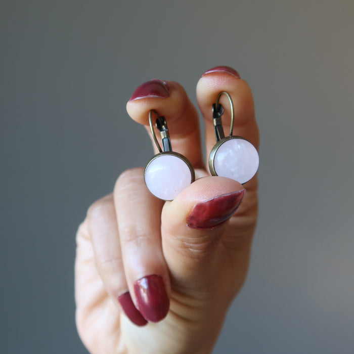 hand holding rose quartz leverback earrings