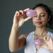 woman meditating with two dark pink star rose quartz eggs
