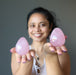 woman holding two dark pink star rose quartz eggs