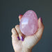 hand holding up dark pink star rose quartz egg