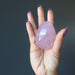 dark pink star rose quartz egg in palm of hand