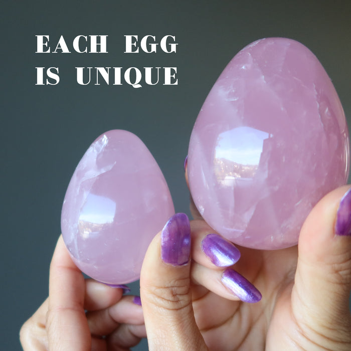hands holding dark pink star rose quartz eggs to show each is unique
