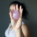 woman holding dark pink star rose quartz egg