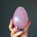 hand holding dark pink star rose quartz egg