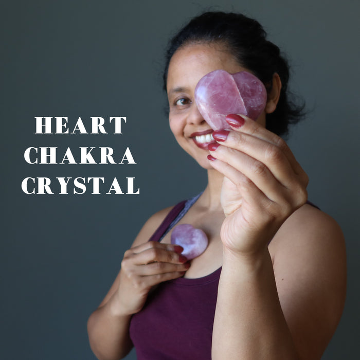 woman holding rose quartz hearts at the heart chakra