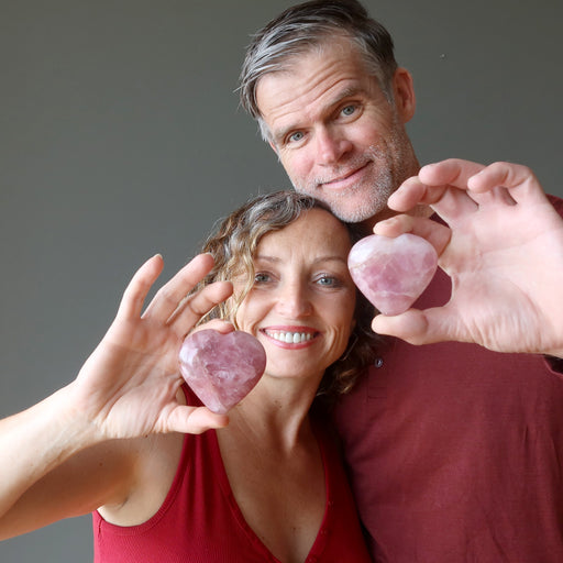 couple holding rose quartz hearts