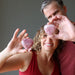 man and woman holding dark pink rose quartz heart