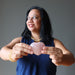 woman holding a pink rose quartz crystal heart