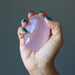 hand holding pink rose quartz polished palm stone