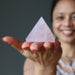 sheila of satin crystals gazing at a pink rose quartz pyramid