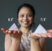 sheila of satin crystals holding two rose quartz pyramids to show size difference