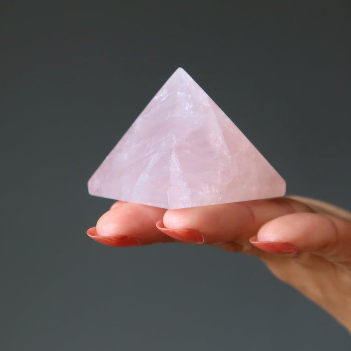 hand holding pink rose quartz pyramid