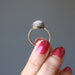 hand holding pink rose quartz oval in antique brass adjustable ring