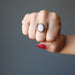 hand wearing pink rose quartz oval in antique brass adjustable ring