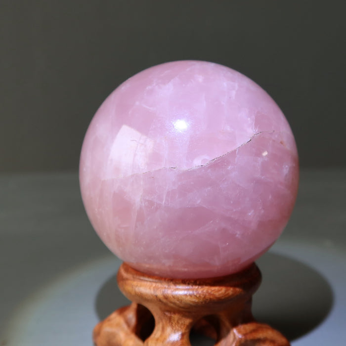 rose quartz sphere on fancy wood display stand