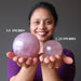 woman holding two star rose quartz spheres