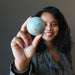 woman holding ruby fuchsite sphere
