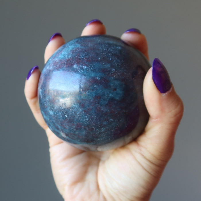 hand holding ruby kyanite sphere