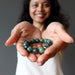 sheila of satin crystals holding out a ruby zoisite round stretch bracelet