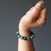 fisted hand wearing a ruby zoisite round stretch bracelet