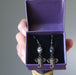 hand holding sardonyx elephant earrings in purple gift box