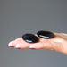 pair of black and brown sardonyx oval stones in palm of hand