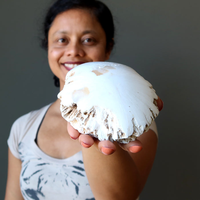 sheila of satin crystals holding raw white scolecite dome