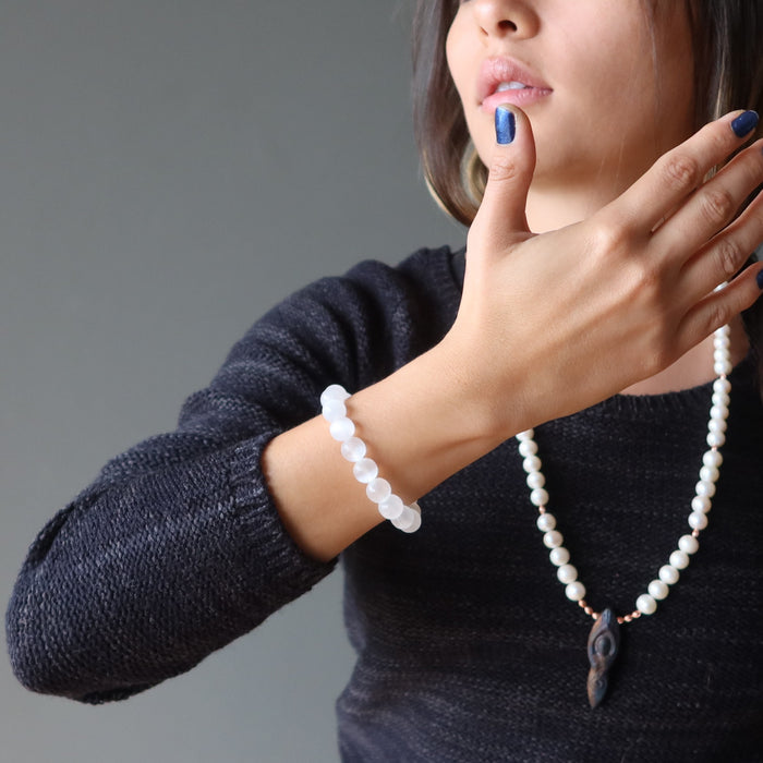 woman wearing white selenite bracelet and pearl necklace