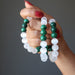 three green malachite and white selenite bead bracelets being held in the hand of lady
