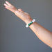 White selenite and green malachite round beaded bracelet on a hand model 