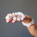 hand holding and wearing white selenite and antique beads stretch bracelet