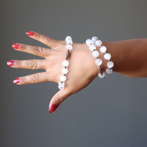 hand wearing white selenite and antique beads stretch bracelets
