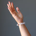hand wearing white selenite and antique beads stretch bracelet