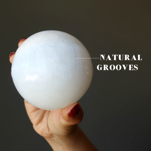 white selenite sphere with natural grooves