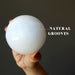 white selenite sphere with natural grooves