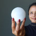 woman looking at white selenite sphere