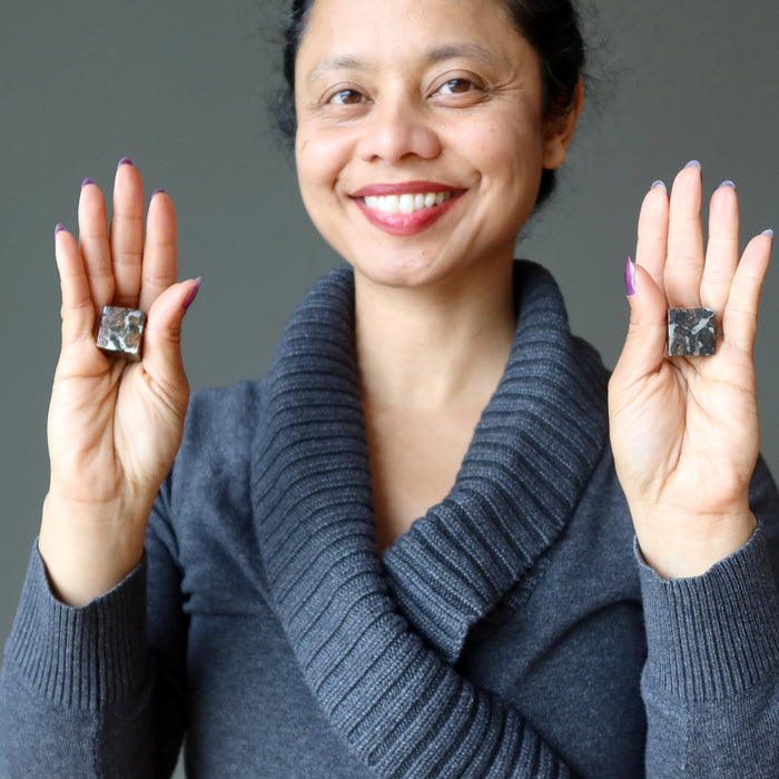 sheila of satin crystals holding two silver and orange sericho meteorite cubes in her hands