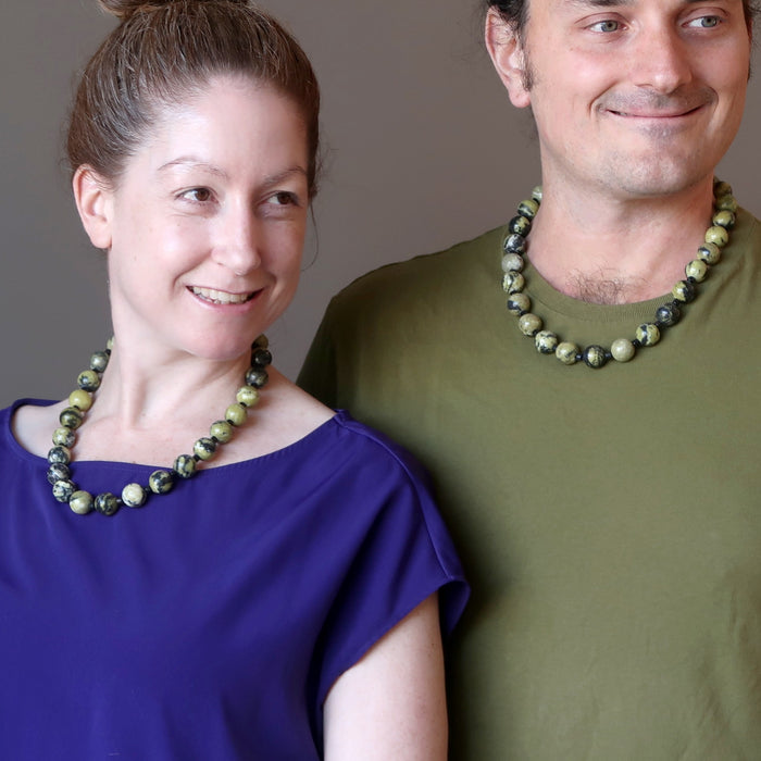 man and woman wearing serpentine necklaces