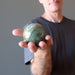 male hand holding  serpentine sphere