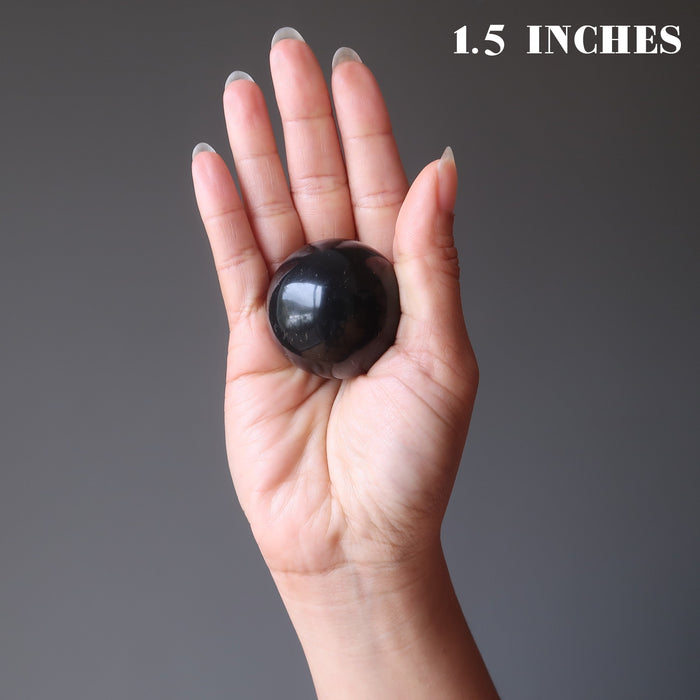 holding up the Shungite Sphere in the palm